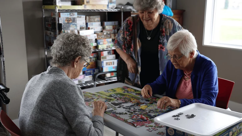 Three elderly women solving Jigsaw puzzle and doing fun activities for seniors